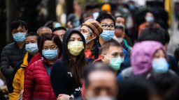 TOPSHOT - People wearing facemasks as a preventative measure following a coronavirus outbreak which began in the Chinese city of Wuhan, line up to purchase face masks from a makeshift stall after queueing for hours following a registration process during which they were given a pre-sales ticket, in Hong Kong on February 5, 2020. - The new coronavirus which appeared late December has claimed nearly 500 lives, infected more than 24,000 people in mainland China and spread to more than 20 countries. (Photo by Anthony WALLACE / AFP) (Photo by ANTHONY WALLACE/AFP via Getty Images)