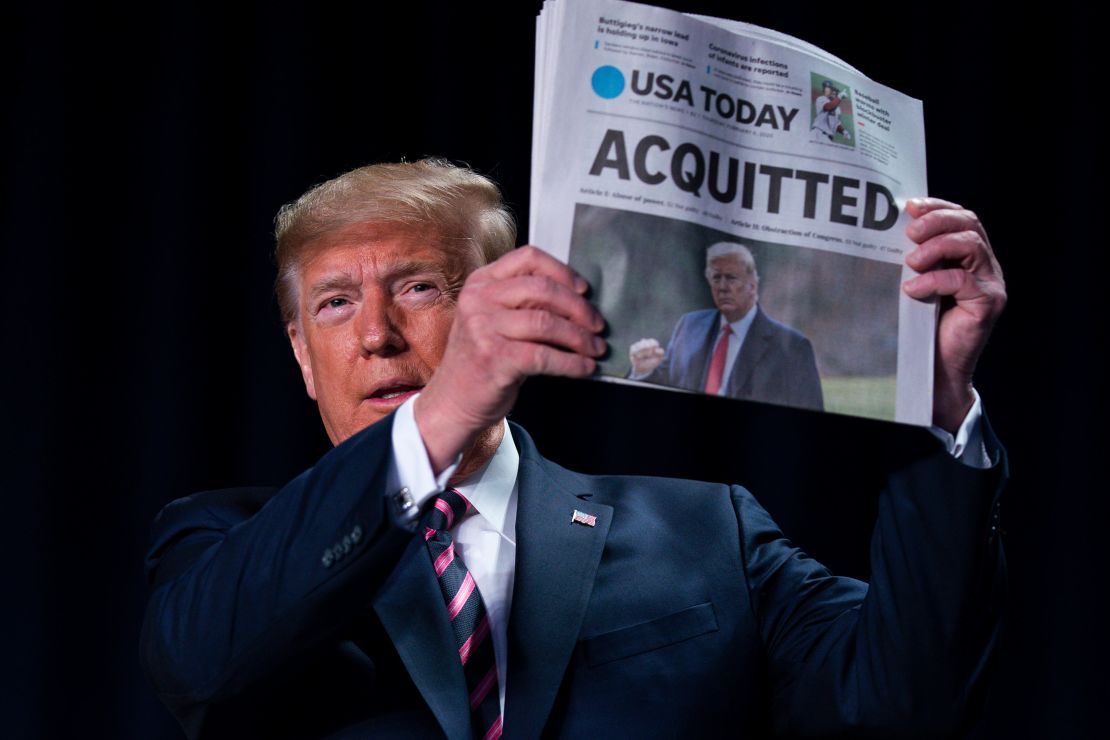 President Donald Trump holds up a newspaper at the 68th annual National Prayer Breakfast in Washington on February 6.