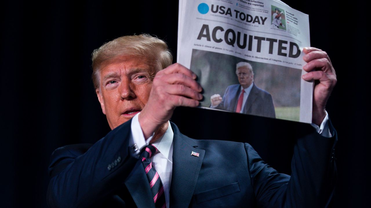 President Donald Trump holds up a newspaper with the headline that reads "ACQUITTED" at the 68th annual National Prayer Breakfast, at the Washington Hilton, Thursday, Feb. 6, 2020, in Washington. (AP Photo/ Evan Vucci)