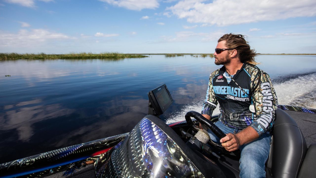 Brandon Medlock drives his boat on Lake Okeechobee, where he says submerged grass used to help filter the water. 