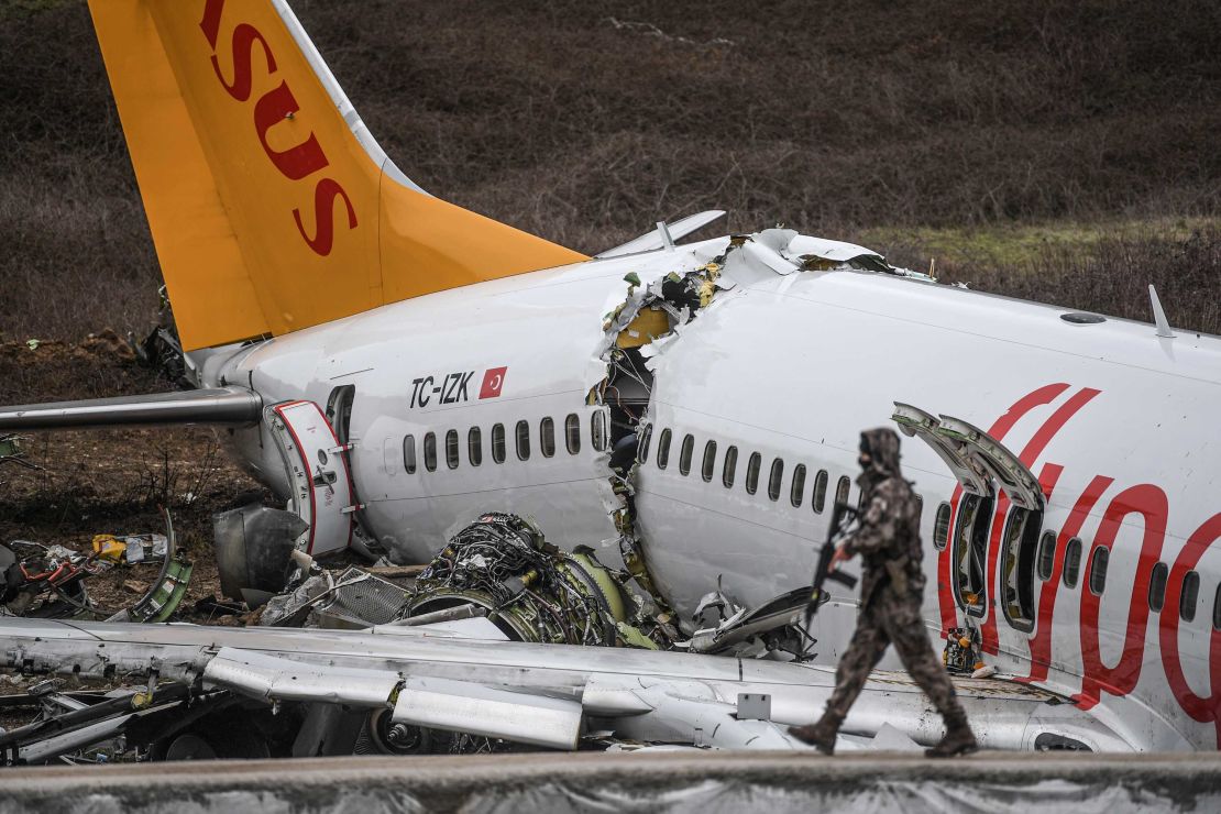 A Turkish soldier patrols in front of the wreckage of the Pegasus Airlines jet that snapped into three parts in Istanbul on Wednesday. 
