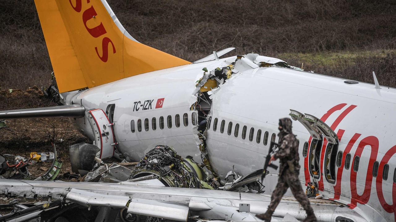 A Turkish soldier patrols in front of the wreckage of the Pegasus Airlines jet that snapped into three parts in Istanbul on Wednesday.