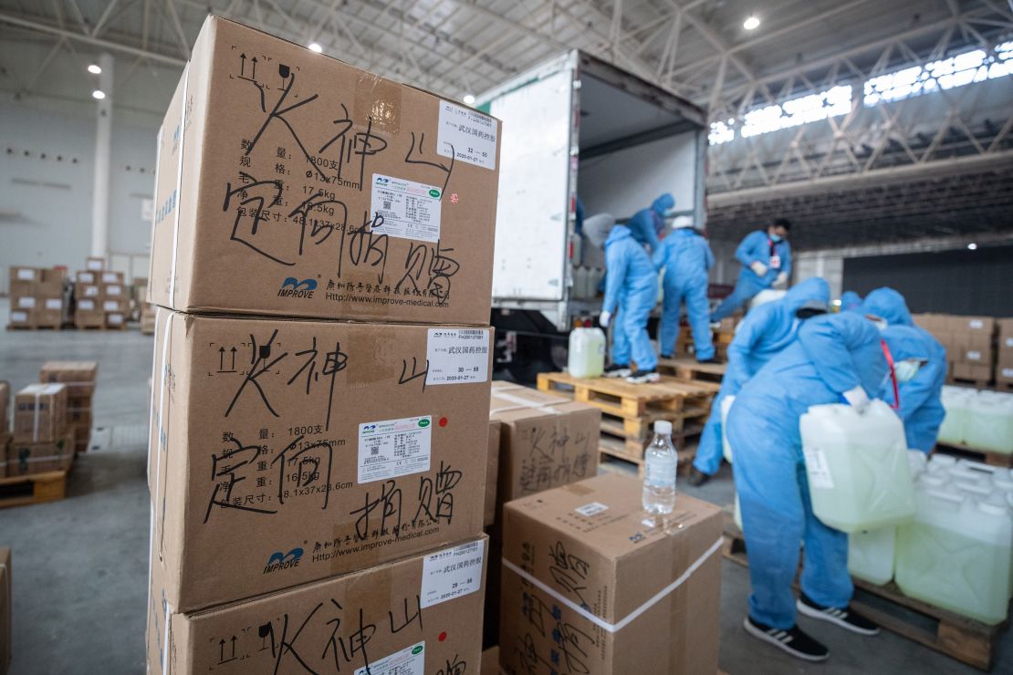 Staff members and volunteers transfer medical supplies at an exhibition center warehouse which has been converted into a makeshift hospital in Wuhan on February 4, 2020.
