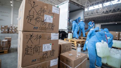 Staff members and volunteers transfer medical supplies at an exhibition center warehouse which has been converted into a makeshift hospital in Wuhan on February 4, 2020.