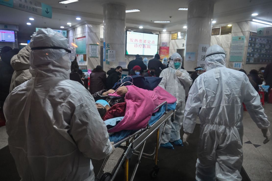 Medical staff arrive with a patient at the Wuhan Red Cross Hospital in Wuhan on January 25, 2020.