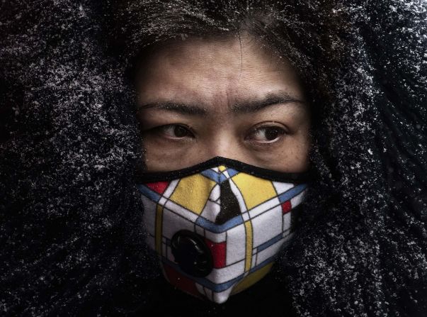 A woman wears a protective mask as she shops in a Beijing market on February 6, 2020.