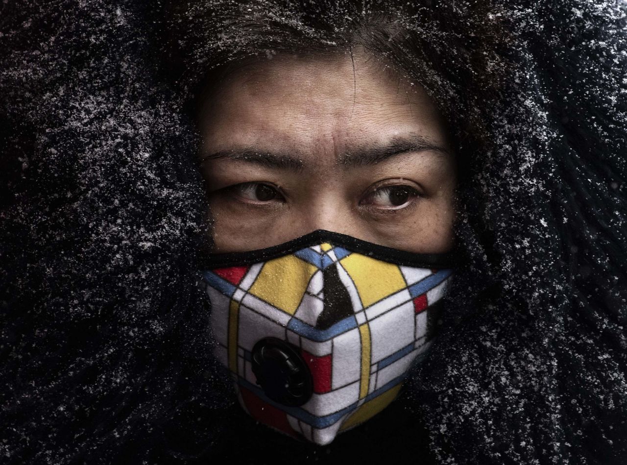 A woman wears a protective mask as she shops in a Beijing market on February 6.