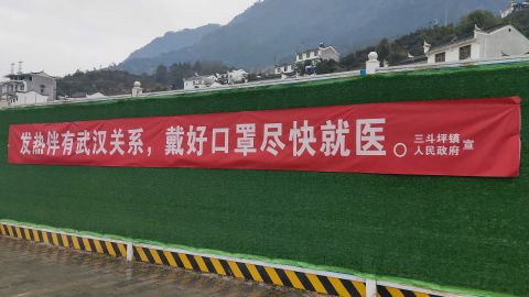 A banner in the Hubei town of Sandouping which reads, "If (you) have fever and links to Wuhan, wear a mask and see a doctor."