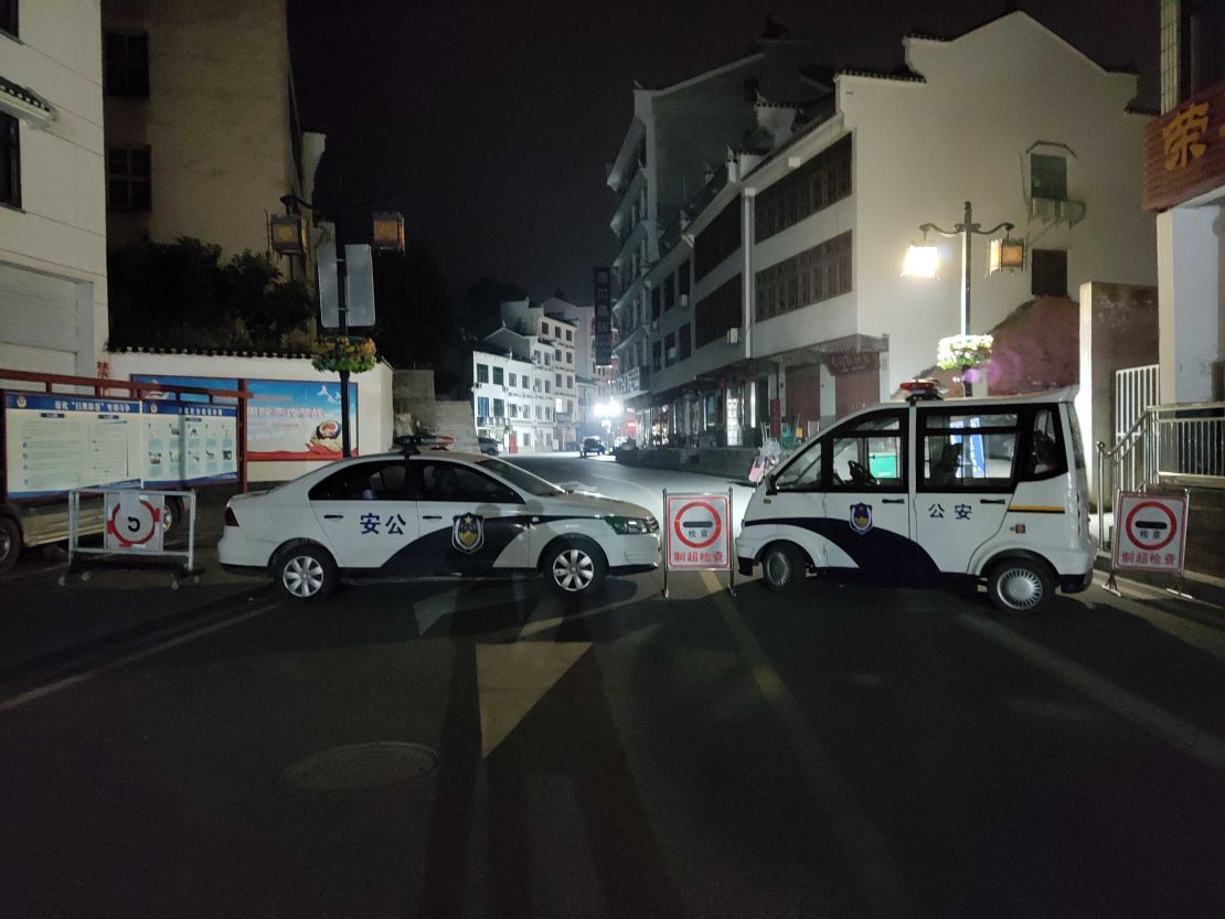 A road block set up by police vehicles on a street in Sandouping.