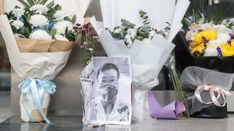 A photo of the late ophthalmologist Li Wenliang is seen with flower bouquets at the Houhu Branch of Wuhan Central Hospital in Wuhan on Friday.