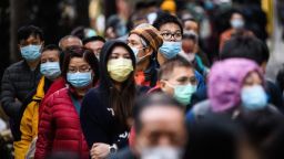 TOPSHOT - People wearing facemasks as a preventative measure following a coronavirus outbreak which began in the Chinese city of Wuhan, line up to purchase face masks from a makeshift stall after queueing for hours following a registration process during which they were given a pre-sales ticket, in Hong Kong on February 5, 2020. - The new coronavirus which appeared late December has claimed nearly 500 lives, infected more than 24,000 people in mainland China and spread to more than 20 countries. (Photo by ANTHONY WALLACE/AFP via Getty Images)