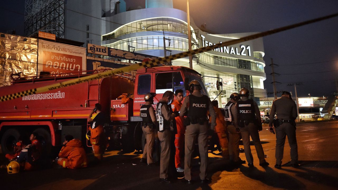 Police and firefighters stand outside the shopping mall.