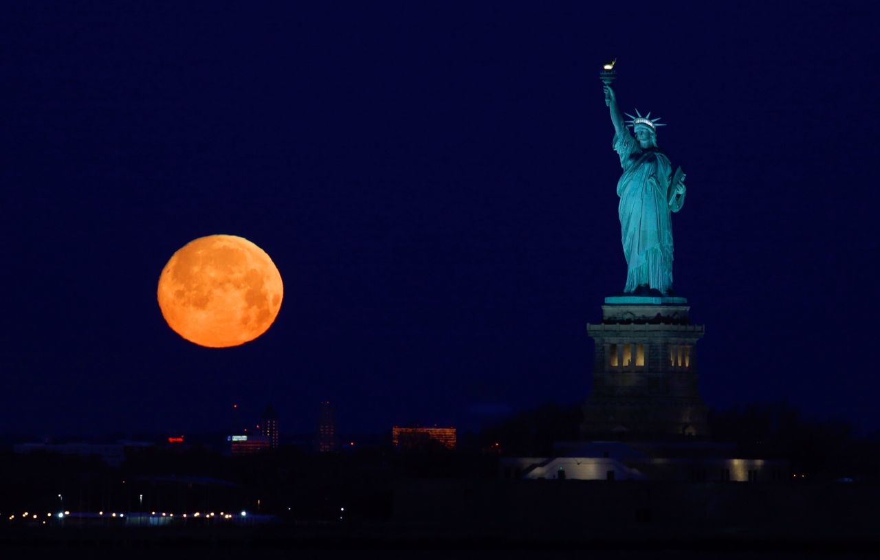 The moon sets beside the Statue of Liberty before sunrise on February 8.