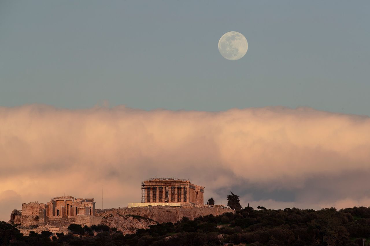 The moon rises behind the ancient Acropolis hill in Athens on February 8.