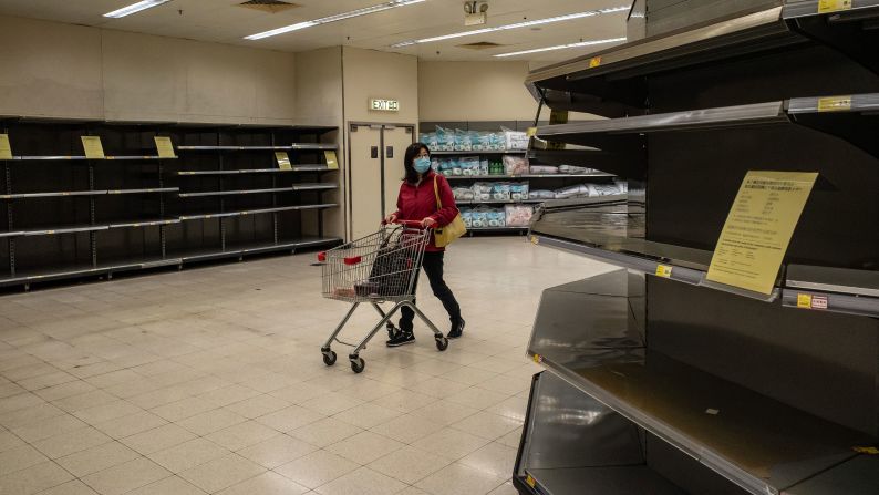 A shopper walks past empty shelves at a grocery store in Hong Kong on February 9, 2020. China's Ministry of Commerce <a href="index.php?page=&url=https%3A%2F%2Fwww.cnn.com%2F2020%2F02%2F06%2Fasia%2Fwuhan-coronavirus-update-intl-hnk%2Findex.html" target="_blank">encouraged supermarkets and grocery stores</a> to resume operations as the country's voluntary or mandatory quarantines began to take an economic toll. 