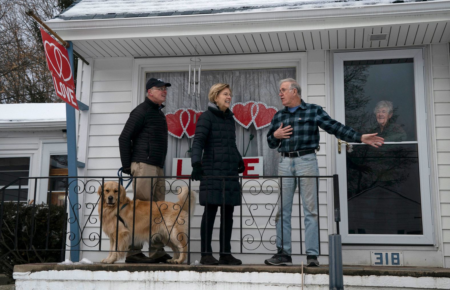 Warren campaigns in Manchester on February 8. Her husband, Bruce Mann, is at left with their dog Bailey.