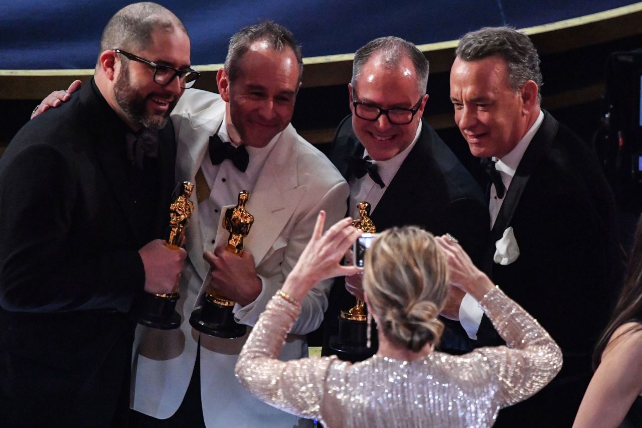 From left, "Toy Story 4" producers Jonas Rivera, Josh Cooley and Mark Nielsen pose with actor Tom Hanks after accepting the Oscar for best animated feature film.