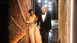 In this handout photo provided by A.M.P.A.S. Regina King and Best Actor in a Supporting Role winner Brad Pitt walk backstage during the 92nd Annual Academy Awards at the Dolby Theatre on February 09, 2020 in Hollywood, California. 