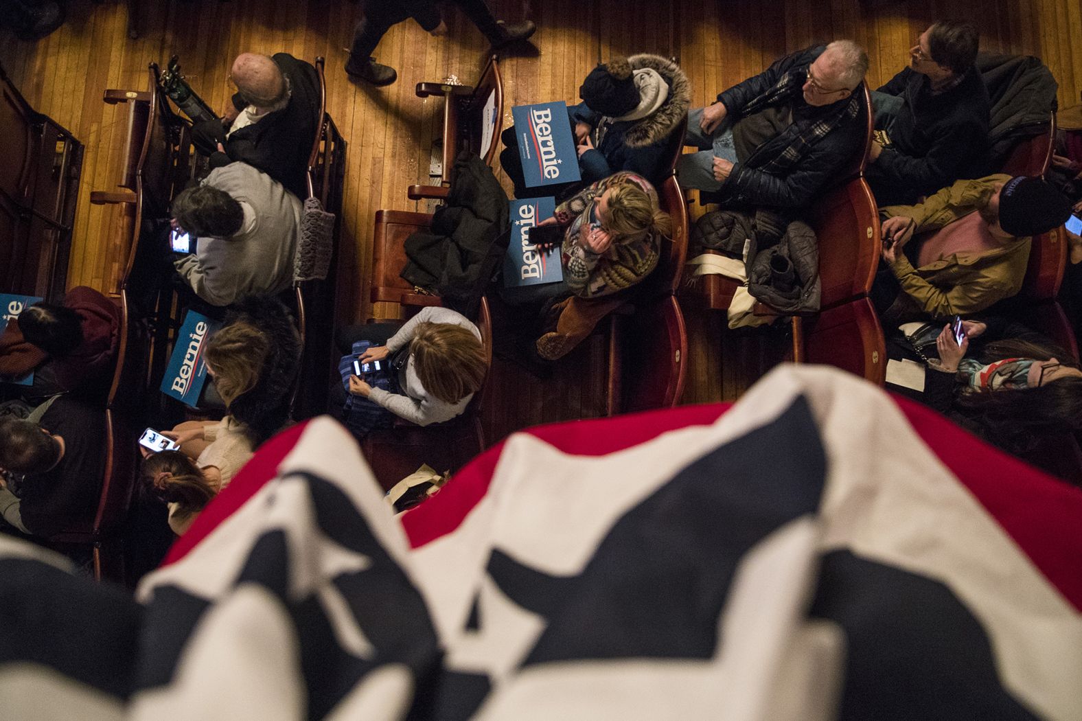 People hold campaign signs as Sanders speaks at a town-hall event in Rochester on February 8.
