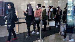 Employees wearing protective face masks queue as they return to work at an office building in Shanghai on February 10, 2020. - Millions of people in China were returning to work on February 10 after an extended holiday designed to slow the spread of the new coronavirus, which has killed more than 900 people in the country. (Photo by NOEL CELIS / AFP) (Photo by NOEL CELIS/AFP via Getty Images)