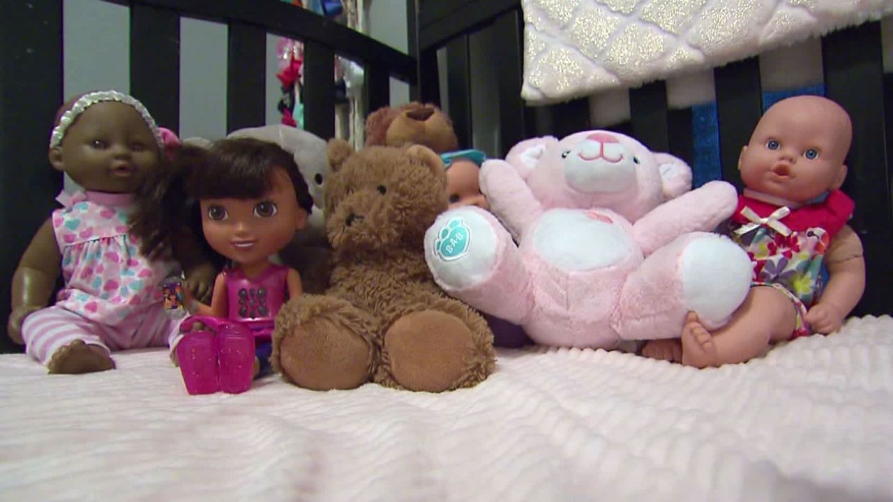 Ruby's crib has a collection of dolls and stuffed animals waiting for her.