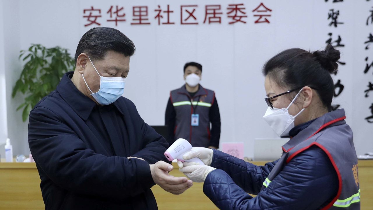 In this photo released by Xinhua News Agency, Chinese President Xi Jinping, left, wearing a protective face mask receives a temperature check as he inspects the novel coronavirus pneumonia prevention and control work at a neighbourhoods in Beijing, Monday, Feb. 10, 2020. China reported a rise in new virus cases on Monday, possibly denting optimism that its disease control measures like isolating major cities might be working, while Japan reported dozens of new cases aboard a quarantined cruise ship. (Pang Xinglei/Xinhua via AP)