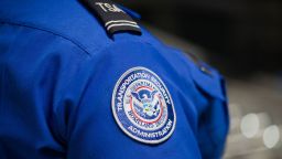 A Transportation Security Administration (TSA) agent's patch is seen as she helps travelers place their bags through the 3-D scanner at the Miami International Airport on May 21, 2019 in Miami, Florida. TSA has begun using the new 3-D computed tomography (CT) scanner in a checkpoint lane to detect explosives and other prohibited items that may be inside carry-on bags.