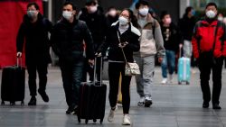 People wearing protective face masks arrive at a railway station in Shanghai on February 10, 2020. - The death toll from the novel coronavirus surged past 900 in mainland China on February 10, overtaking global fatalities in the 2002-03 SARS epidemic, even as the World Health Organization said the outbreak appeared to be stabilising.