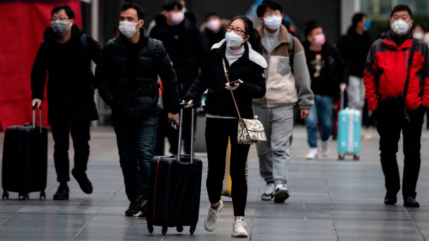 People wearing protective face masks arrive at a railway station in Shanghai on February 10, 2020. - The death toll from the novel coronavirus surged past 900 in mainland China on February 10, overtaking global fatalities in the 2002-03 SARS epidemic, even as the World Health Organization said the outbreak appeared to be stabilising.