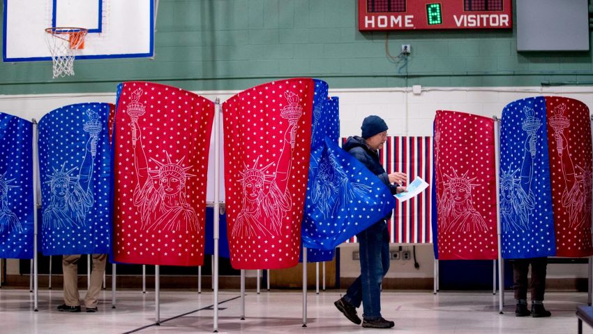 A man walks out of a voting booth during the New Hampshire Primary at Parker-Varney Elementary School, Tuesday, Feb. 11, 2020, in Manchester, N.H. (AP Photo/Andrew Harnik)