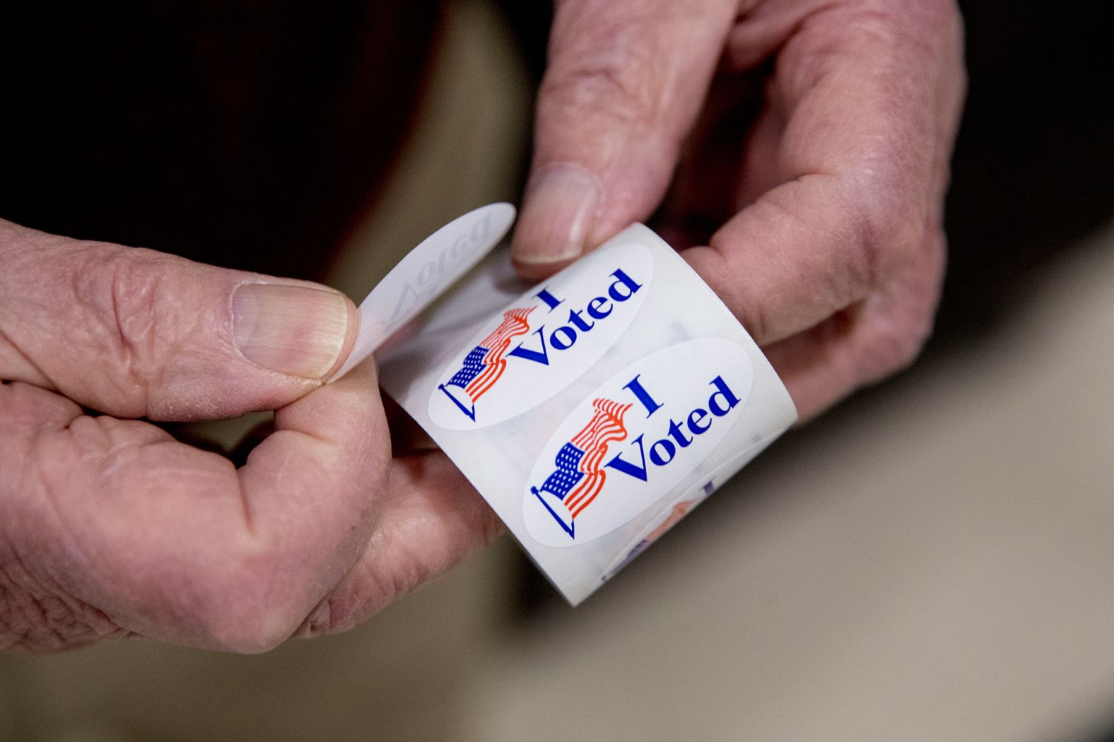An election worker holds a roll of "I voted" stickers in Manchester on February 11.