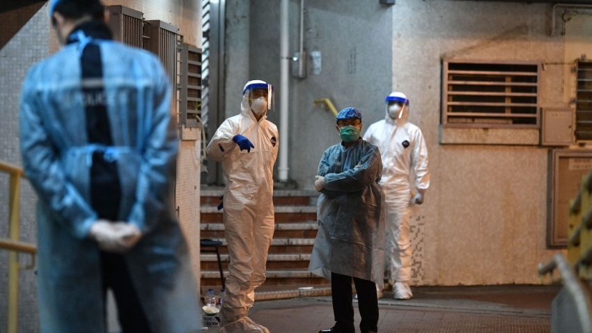 Medical personnels wearing protective suits wait near a block's entrance in the ground of a residential estate, in Hong Kong, early on February 11, 2020, after two people in the block were confirmed to have contracted the coronavirus according to local newspaper reports. (Photo by Anthony WALLACE / AFP) (Photo by ANTHONY WALLACE/AFP via Getty Images)