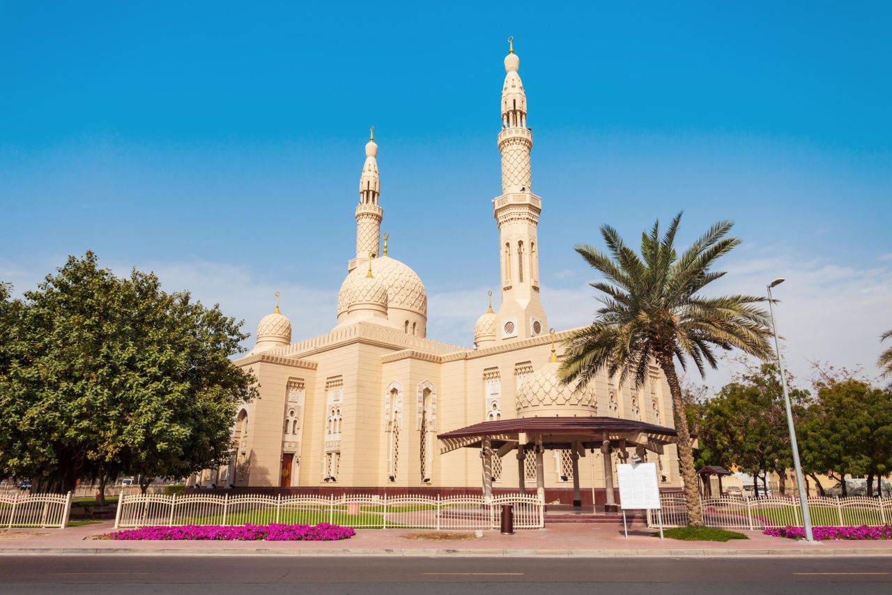 The pale walls of Jumeirah Mosque stand out against a deep blue desert sky.