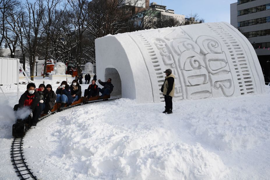 <strong>Feast for the eyes:</strong> People ride a mini steam locomotive through the "Cup Noodles snow tunnel" at the 2020 Sapporo Snow Festival in Japan. 