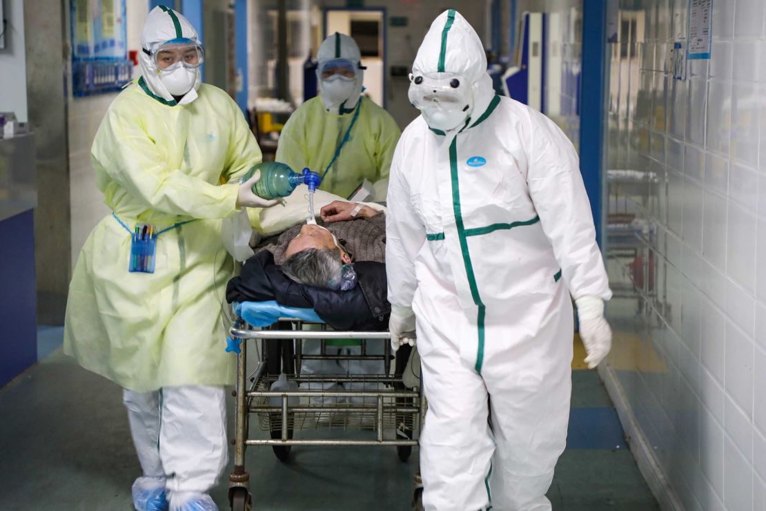 Medical workers in protective suits move a patient at an isolated ward of a hospital in Wuhan on February 6.