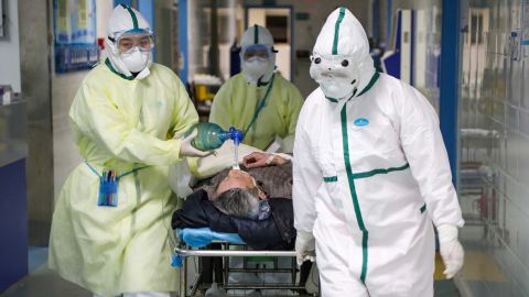Medical workers in protective suits move a patient at an isolated ward of a hospital in Wuhan on February 6.