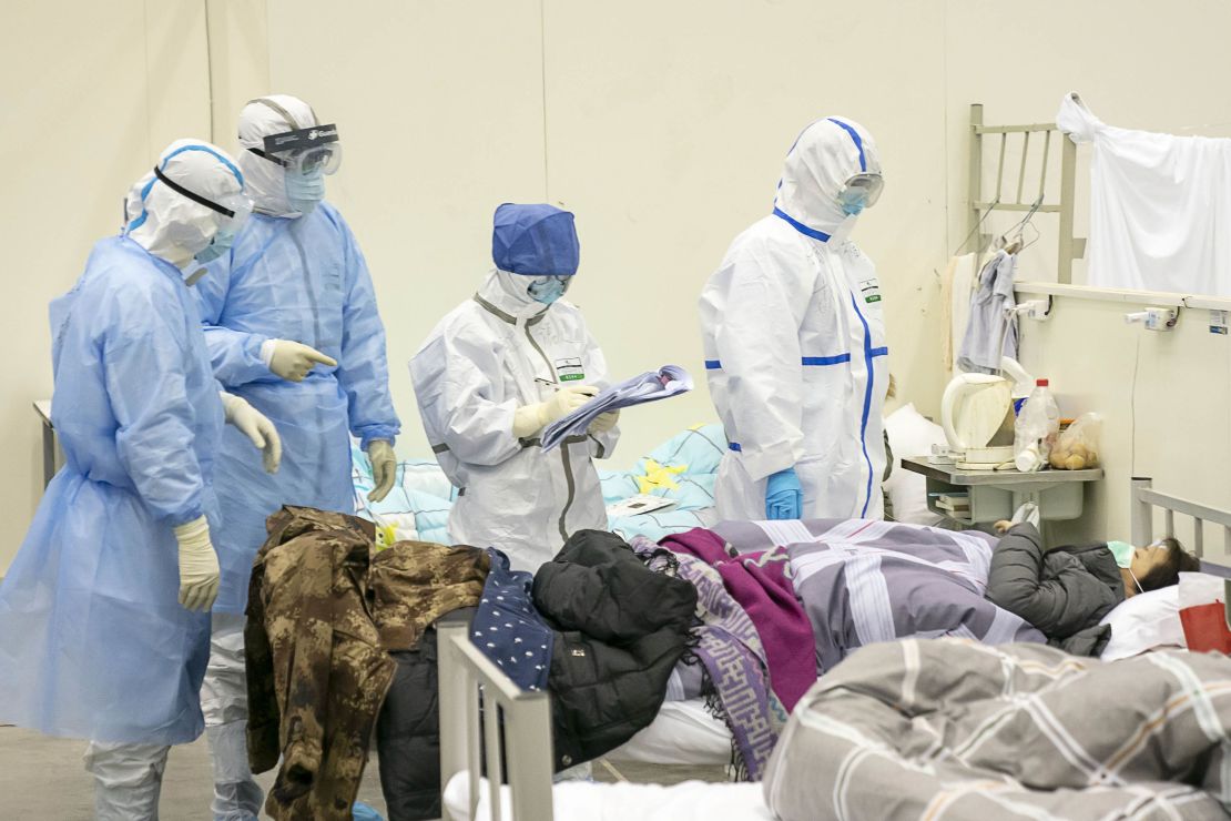Medical staff check a patient's condition at a temporarily converted hospital for coronavirus patients in Wuhan.