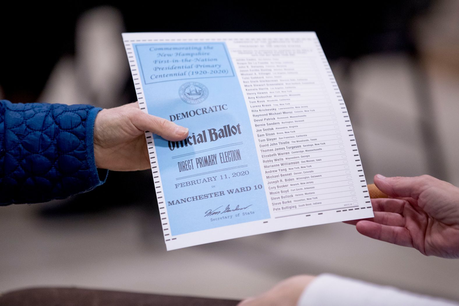 A woman takes a Democratic ballot in Manchester.