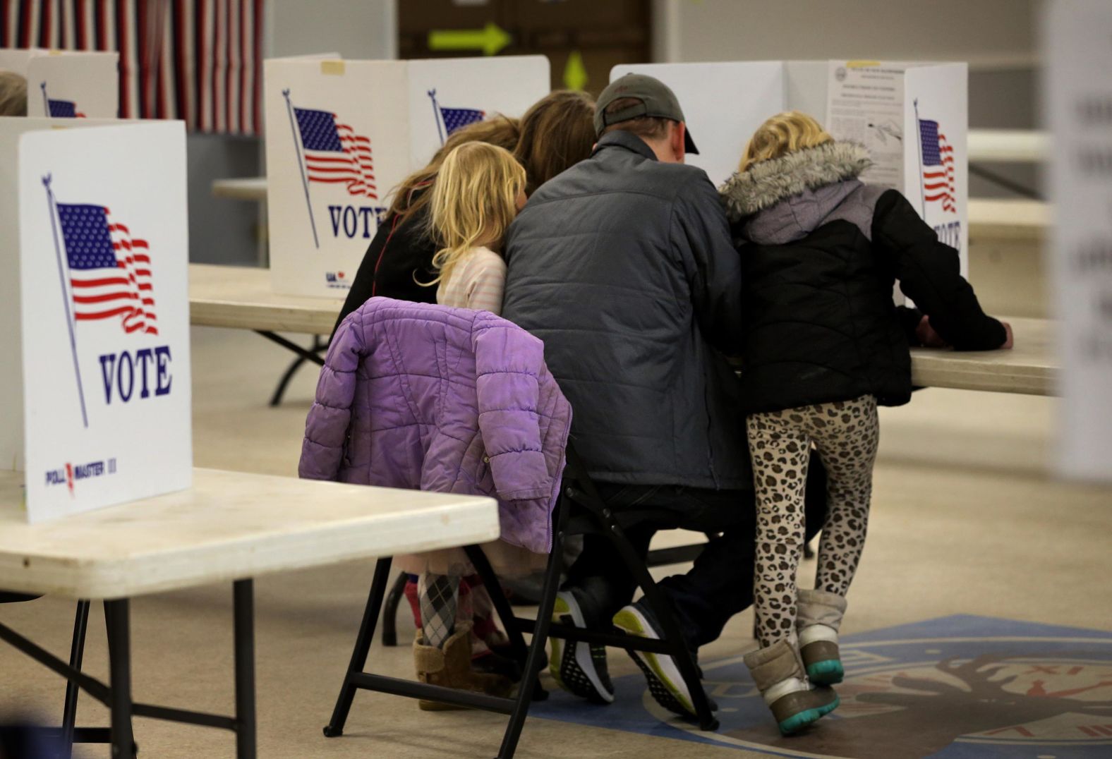 William Swan is joined by his daughters while voting in Dover, New Hampshire.