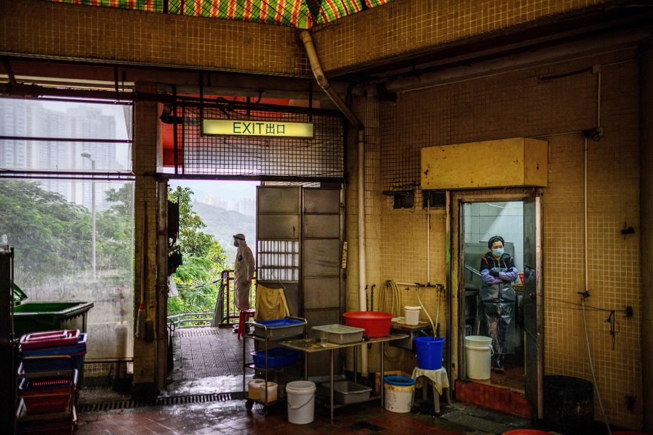 A police officer, left, wears protective gear as he guards a cordon at the Hong Mei House in Hong Kong on February 11.