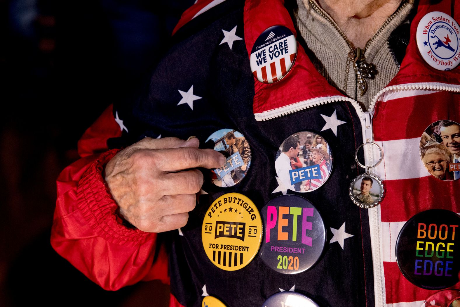 Campaign buttons cover the jacket of Pat Provencher, a Buttigieg supporter, at Buttigieg's rally in Nashua.