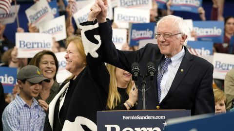 Sanders holds the hand of his spouse Jane O'Meara Sanders as he takes the stage during a primary night event on February 11, 2020 in Manchester, New Hampshire. 