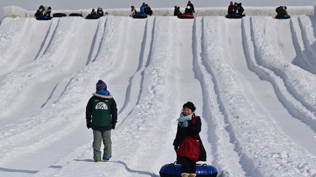 <strong>Snowy thrills: </strong>People take part in snow tubing during the Sapporo Snow Festival in Sapporo on February 5, 2020. Due to the shortage of snow, the 100-meter-long snow slide was cut to 70 meters this year. 