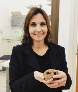 Dr. Hila May holding a hadrosaur vertebra