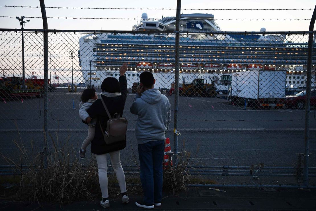 Relatives of passengers wave to the Diamond Princess cruise ship, which has around 3,600 people quarantined onboard due to fears of the new coronavirus.