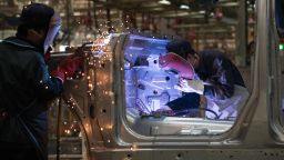Workers weld SUV parts at the BAIC (Beijing Automotive Group Co) SUV assembly line in Beijing on August 29, 2018.