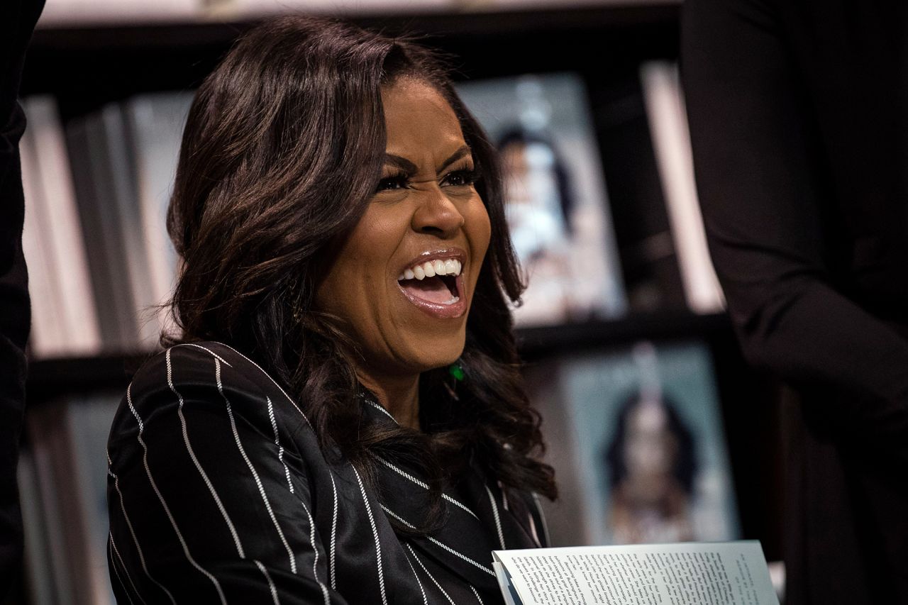 Obama laughs while signing copies of her memoir "Becoming" in November 2018. She'd go on to win a best spoken word album Grammy for the audio version of her best-selling book.