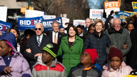 Democratic presidential candidates, former Vice President Joe Biden, left, Minnesota Sen. Amy Klobuchar, Massachusetts Sen. Elizabeth Warren and Vermont Sen. Bernie Sanders, right, march down Main St. to the King Day at the Dome event on January 20, 2020, in Columbia, South Carolina.