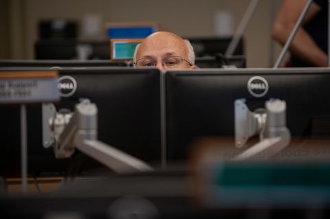 A CDC employee works on his computer.