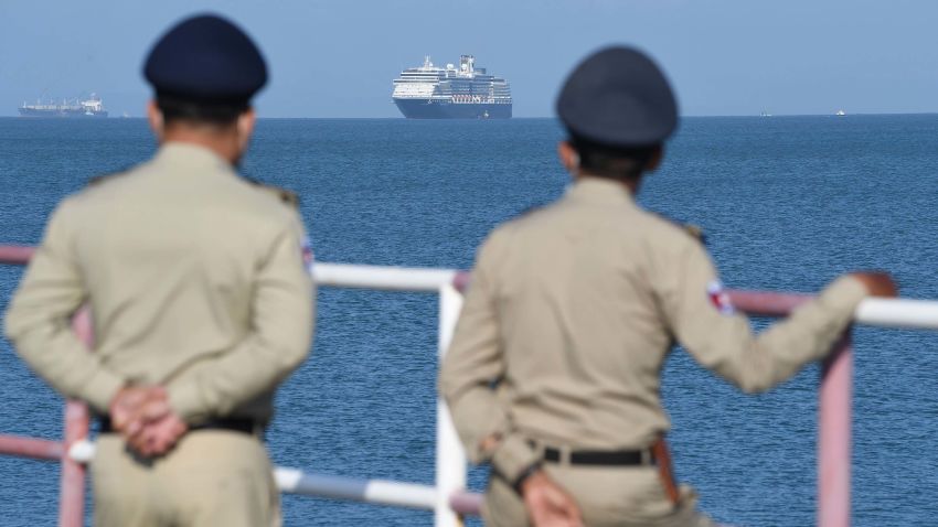 The Westerdam cruise ship is seen past Cambodian policemen as it approaches port in Sihanoukville, Cambodia's southern coast on February 13, 2020, where the liner had received permission to dock after been refused entry at other Asian ports due to fears of the COVID-19 coronavirus. - Japan, Guam, the Philippines, Taiwan and Thailand all refused to allow the ship to dock, despite operator Holland America insisting there were no cases of the deadly disease -- which has killed over 1,100 -- on board. (Photo by TANG CHHIN Sothy / AFP) (Photo by TANG CHHIN SOTHY/AFP via Getty Images)